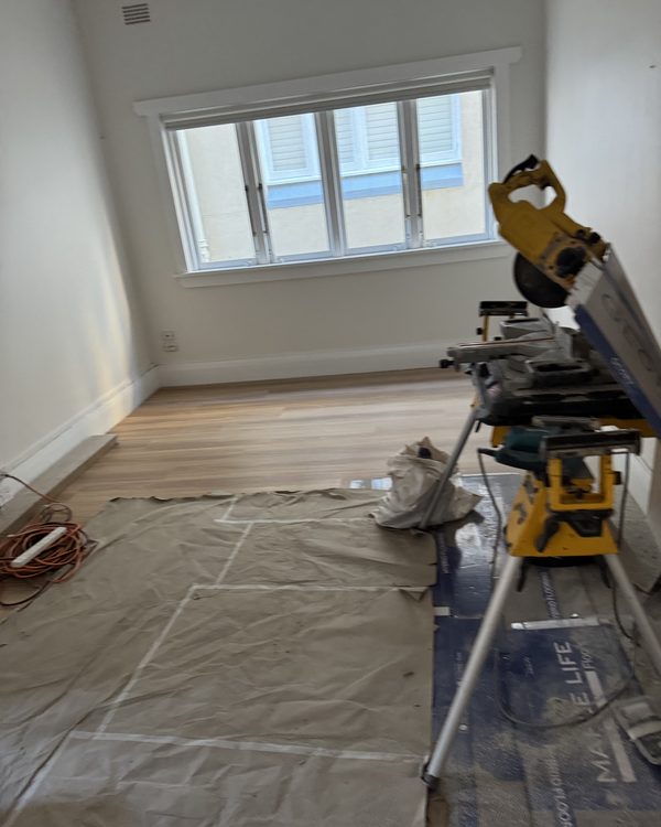 Mitre saw and materials set up in a room being floored
