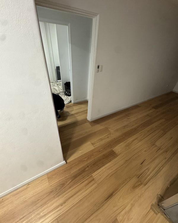 Warm-toned plank flooring running through a hallway