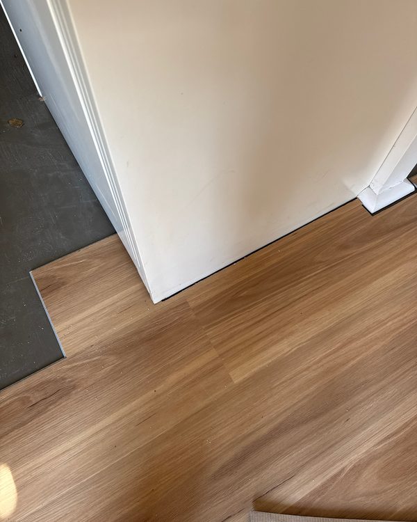 Close detail of plank grain meeting a painted wall