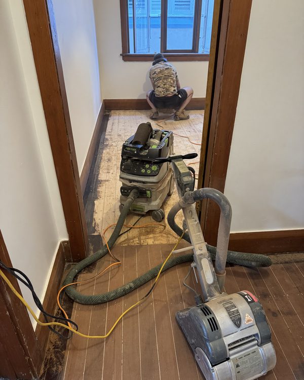 Edge sander with dust extraction working the perimeter of a room