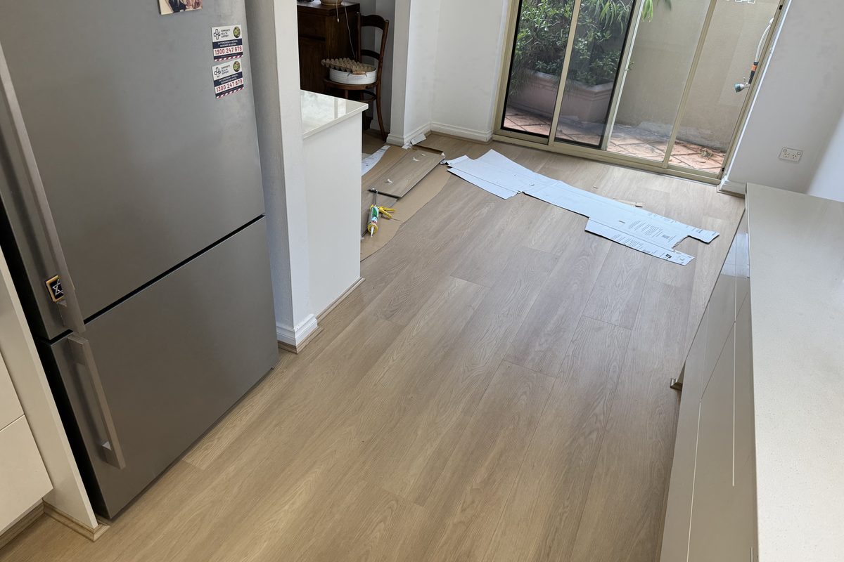 Hybrid plank flooring laid through a kitchen and dining space