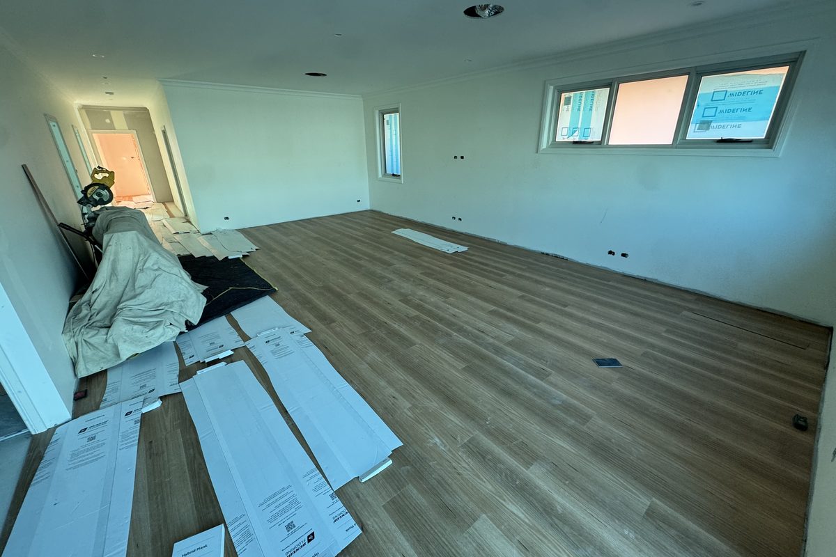 An empty room part-way through a hybrid plank installation