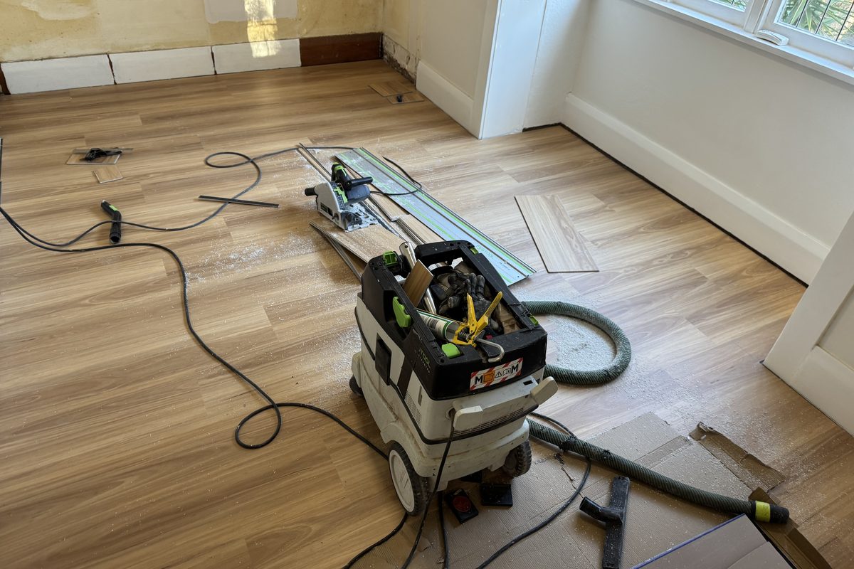 Track saw and M-class dust extractor set up on a protected floor