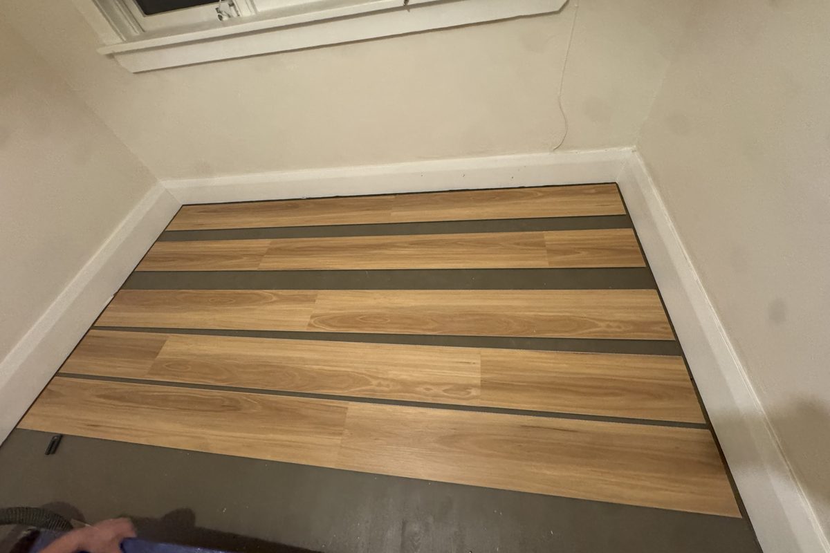 Planks being laid over underlay, with the underlay visible between runs